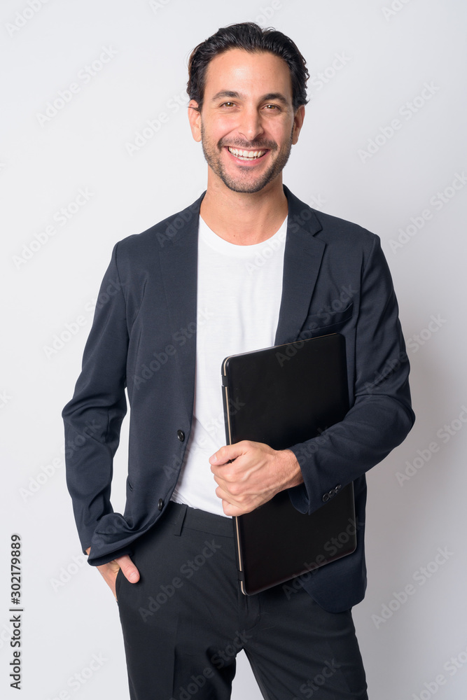Portrait of happy handsome Hispanic businessman holding laptop Portrait of happy handsome Hispanic businessman holding laptop