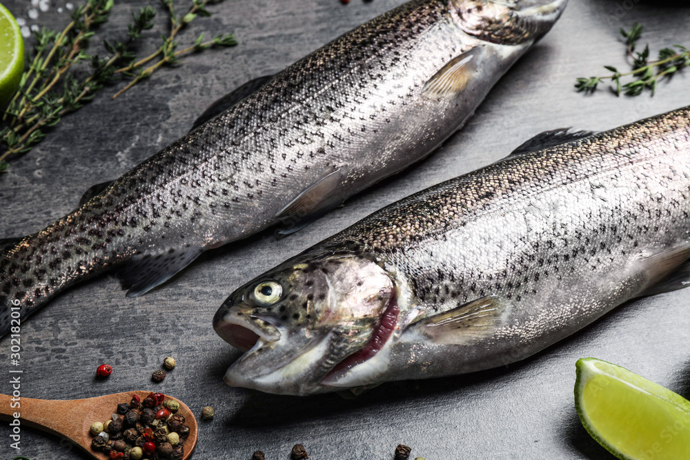 Raw cutthroat trout fish on grey table, closeup Raw cutthroat trout fish on grey table, closeup
