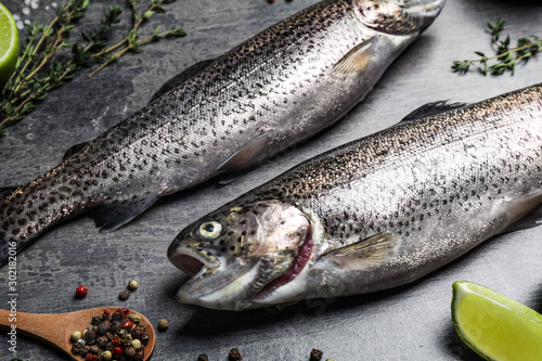 Raw cutthroat trout fish on grey table, closeup