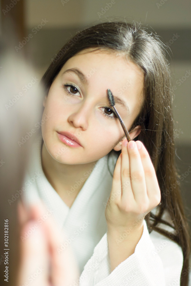 Female beauty, beautiful teen girl applying make up in bathroom at home. Female beauty, beautiful teen girl applying make up in bathroom at home.