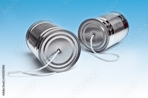 Communications and business calls concept of tin can telephone with string on blue corporate style background photo