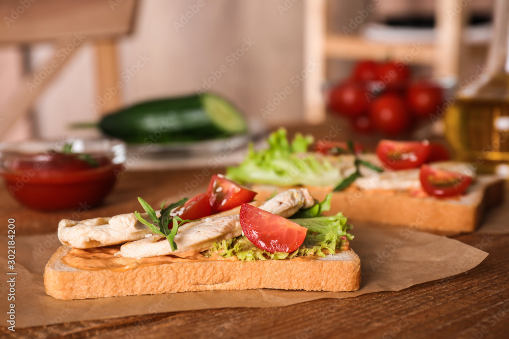 Delicious sandwiches with chicken on wooden table Delicious sandwiches with chicken on wooden table