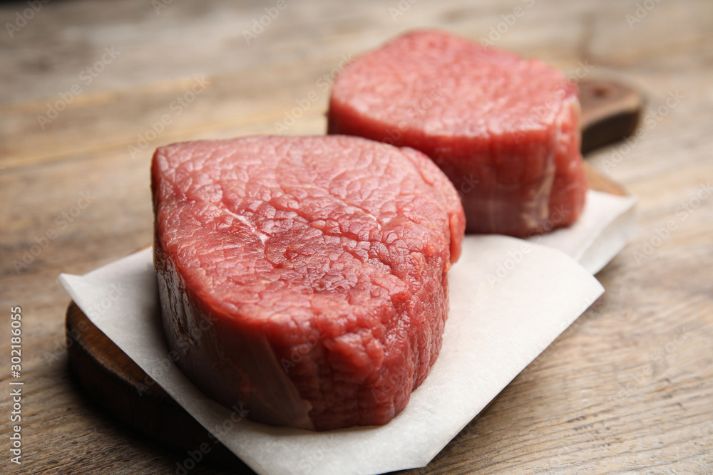 Fresh raw beef cut on wooden table, closeup Fresh raw beef cut on wooden table, closeup