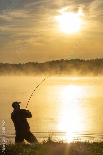Valokuvatapetti angler silhouette during hazy summer sunrise