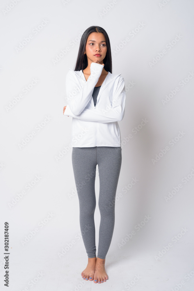 Full body shot of young Asian woman thinking ready for gym Full body shot of young Asian woman thinking ready for gym