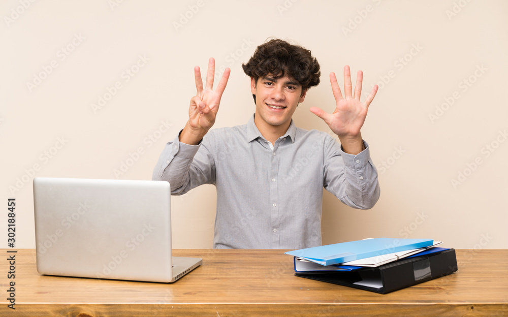 Young student man with a laptop counting eight with fingers Young student man with a laptop counting eight with fingers