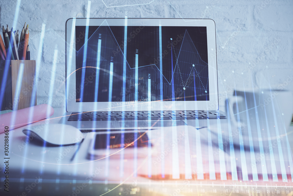 Stock market graph on background with desk and personal computer. Double exposure. Concept of financial analysis.