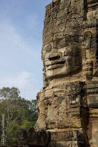 large buddha face carved on stone in angkor thom temple