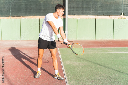Young Man Playing Tennis Outdoors. © MCStock