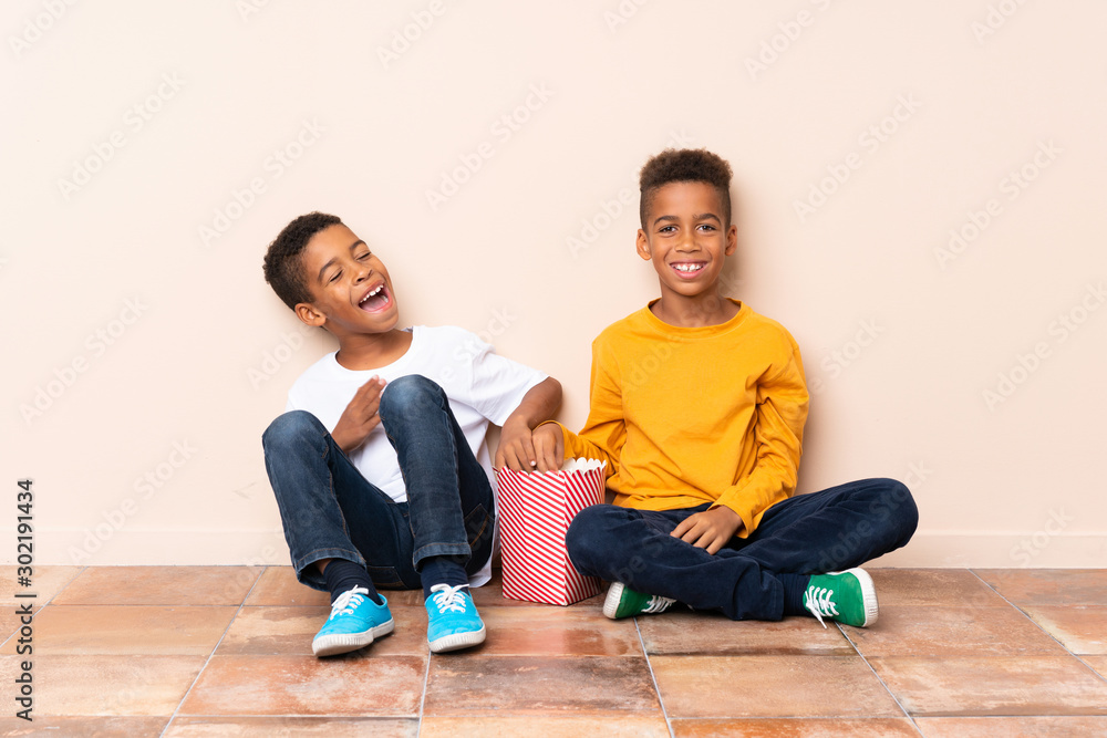 Happy African American brothers holding popcorns Happy African American brothers holding popcorns
