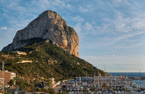 Huge limestone rock located in Natural Park of Penyal d'Ifac situated in Calpe touristic town. Moored yachts boats in the harbour of the city, Costa Blanca, Province of Alicante, Spain