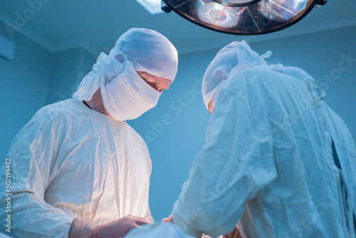 surgeon with assistant during surgery. Bottom view.