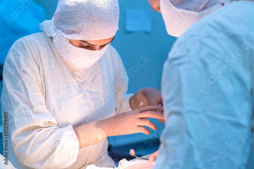 Surgeon girl in a sterile mask during surgery