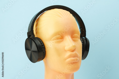 Obraz na płótnie White mannequin head wears wireless headphones on blue background w salonie