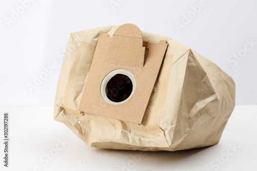 Used paper vacuum cleaner bag with garbage on white background