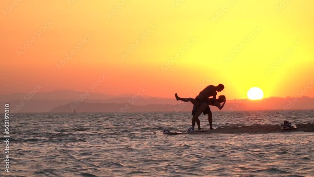 Romantic sunset at the beach, couple is kissing, silhouette, slow motion Romantic sunset at the beach, couple is kissing, silhouette, slow motion