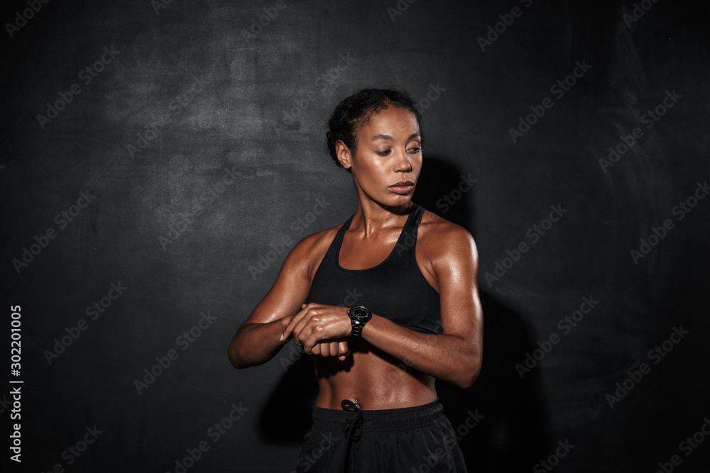 Attractive muscular young african sportswoman standing
