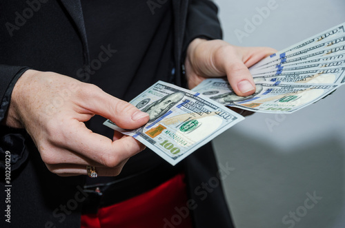 female hands give dollars. Close-up. Business concept.