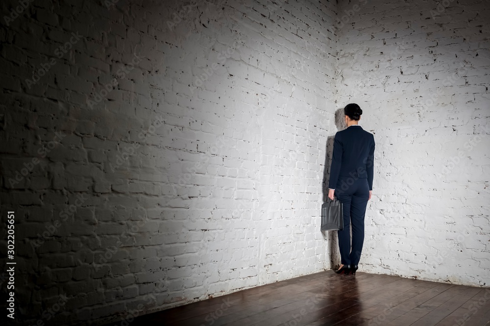 Full length rear view of businesswoman standing in corner at office Full length rear view of businesswoman standing in corner at office