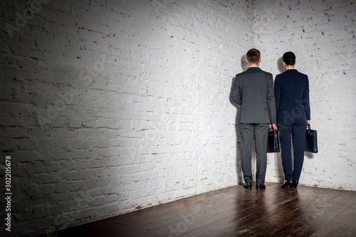 Full length rear view of business colleagues standing in corner at office