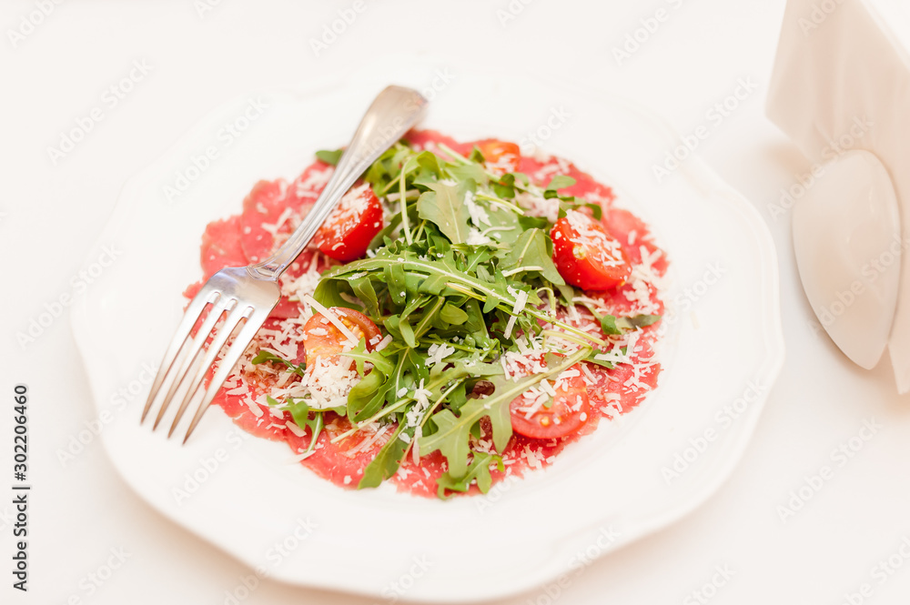 Arugula tomatoes on a white plate in a restaurant on a banquet table Arugula tomatoes on a white plate in a restaurant on a banquet table