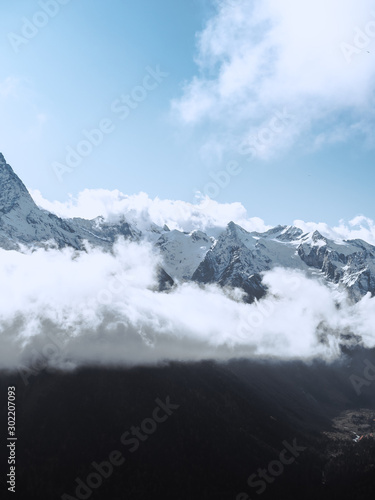 Beautiful landscape of snowy Caucasus mountains in the village of Dombay, Karachay-Cherkessia, Russia. Huge cold lonely snow cliffs high in the clouds,