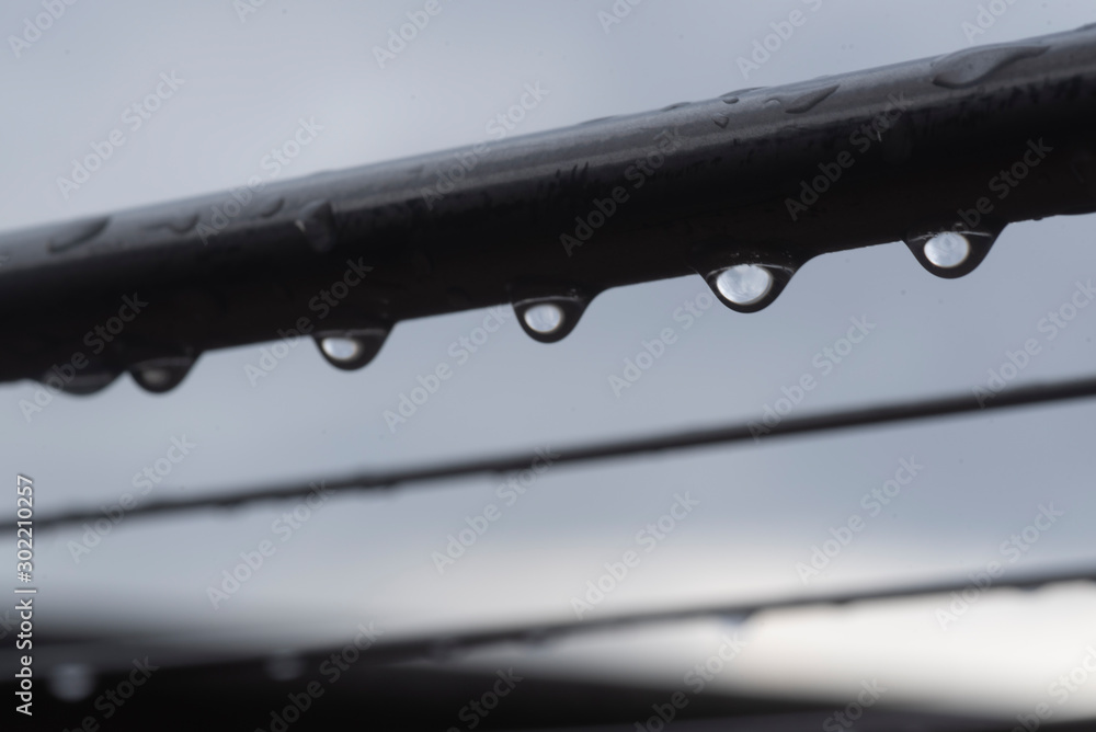 A close up macro photo of water drops hanging on clothe hanging rail A close up macro photo of water drops hanging on clothe hanging rail