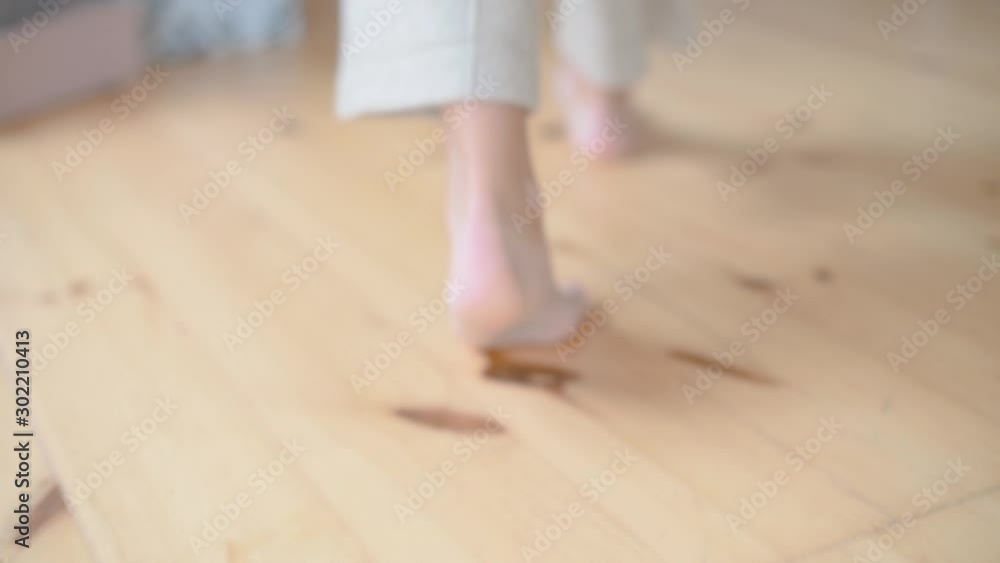 Back view woman walking on wooden floor Back view woman walking on wooden floor