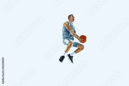 High flight. Young caucasian basketball player of team in action, motion in jump isolated on white background. Concept of sport, movement, energy and dynamic, healthy lifestyle. Training, practicing.