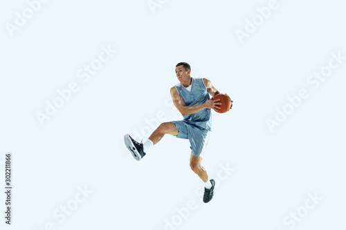 High flight. Young caucasian basketball player of team in action, motion in jump isolated on white background. Concept of sport, movement, energy and dynamic, healthy lifestyle. Training, practicing. © master1305