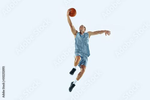 High flight. Young caucasian basketball player of team in action, motion in jump isolated on white background. Concept of sport, movement, energy and dynamic, healthy lifestyle. Training, practicing. © master1305