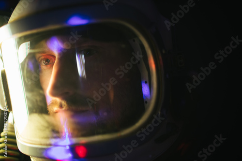 Astrounaut man in a helmet looking ahead exploring the earth in a dark