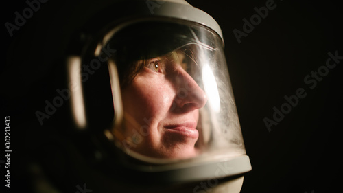 Astrounaut woman in a helmet looking ahead exploring the earth in a dark © 4Max