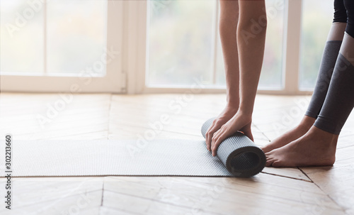Cropped image of woman rolling sport mat at studio