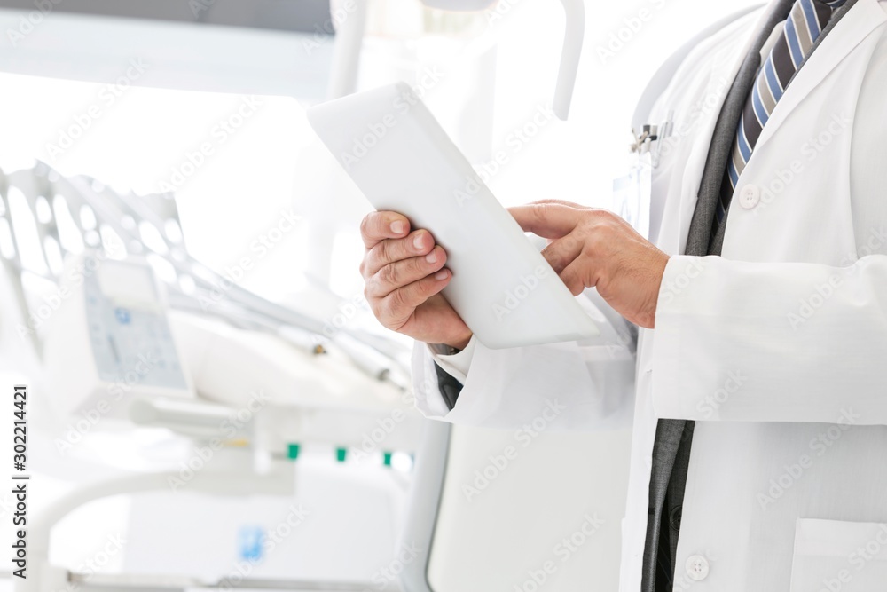 Dentist using digital tablet in clinic Dentist using digital tablet in clinic