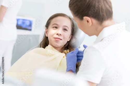 Dentist talking to child patient in clinic