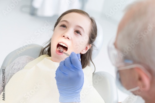 Doctor cleaning or pulling patient teeth in clinic