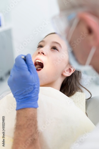 Doctor cleaning or pulling patient teeth in clinic