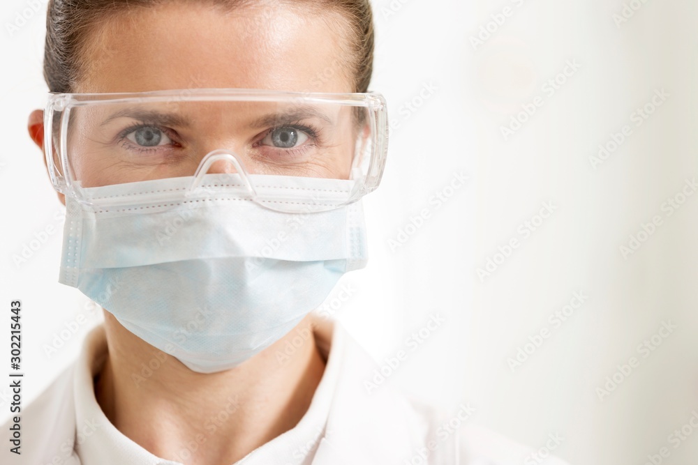 Close up of surgeon wearing mask in clinic Close up of surgeon wearing mask in clinic