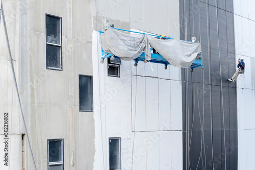 The painter is working to paint the building. photo