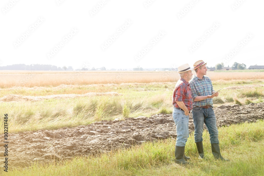 Farmers standing while discussing plans in field