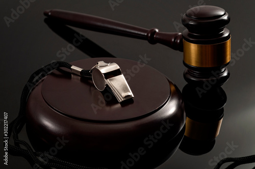 Whistleblower protection law and freedom of information legislation conceptual idea with metal whistle and wooden judge gavel on dark background photo