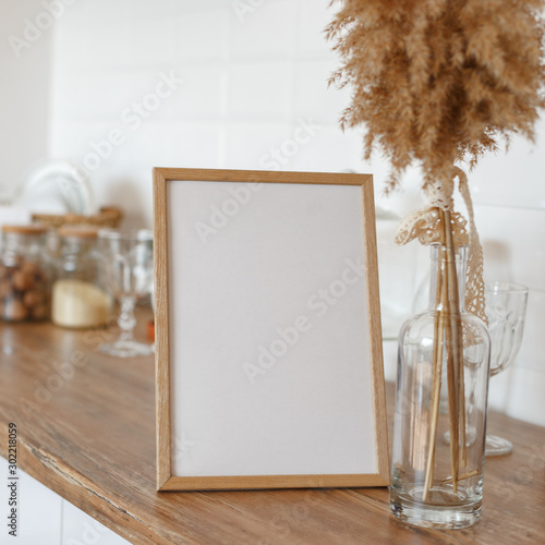 Wooden frame on the kitchen table in the interior.