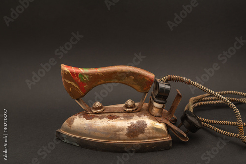 Old iron isolated on black background. Vintage rusty iron
