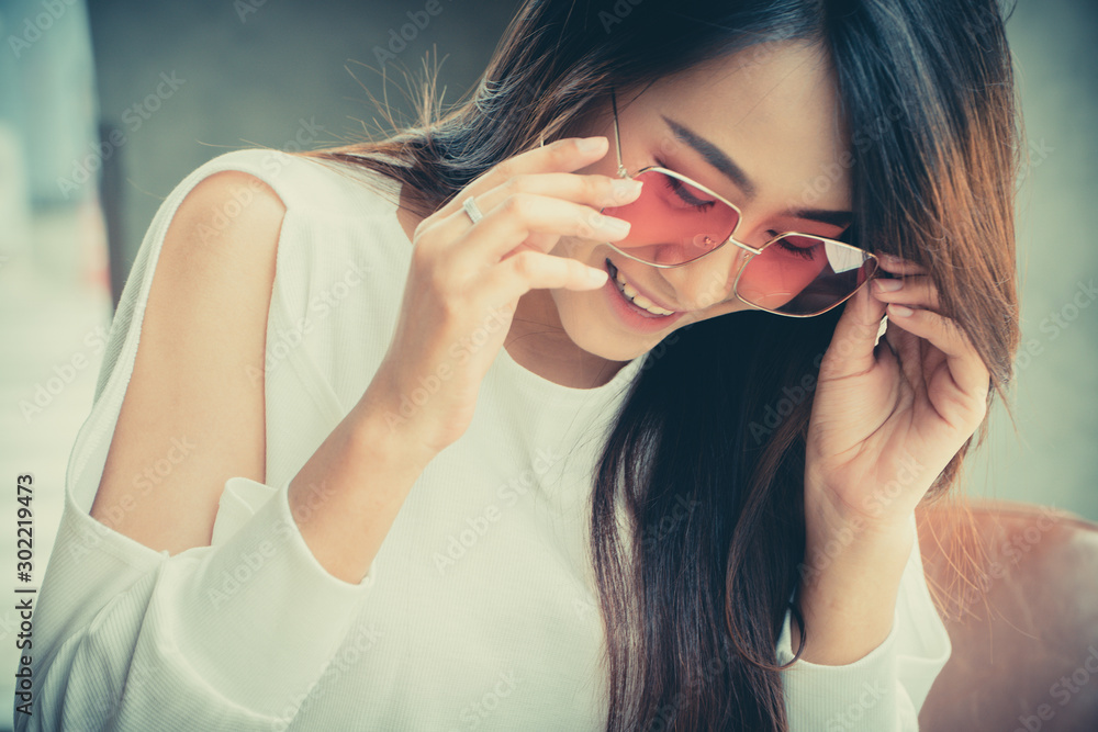 portrait of beautiful Asian women wear sunglasses and sitting in a coffee shop. portrait of beautiful Asian women wear sunglasses and sitting in a coffee shop.