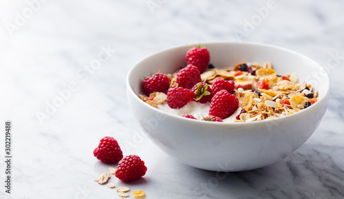 Healthy breakfast. Fresh granola, muesli with yogurt and berries. Marble background. Close up. Copy space. photo
