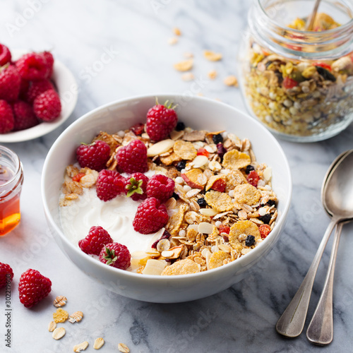 Healthy breakfast. Fresh granola, muesli with yogurt and berries. Marble background. Close up