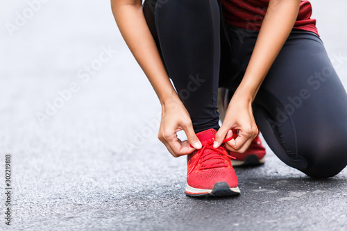 Woman runner tied her shoelace before start running.