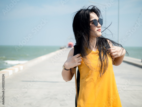 Asian woman with backpack have fun on the Hua Hin pier in sunny day.