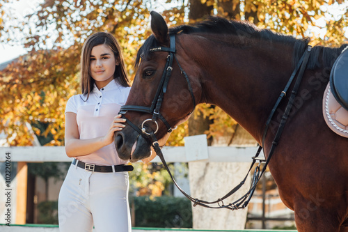 Young woman in special uniform and horse. Equestrian sport concept.